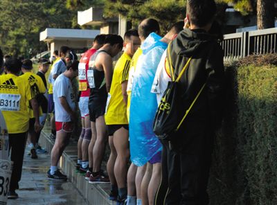 2013年10月20日，北京馬拉松比賽，由于廁位有限，一些選手在綠化帶“就地解決”。圖/IC