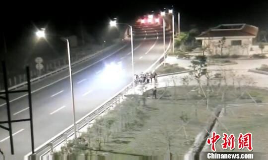 看到車輛經(jīng)過，孩子們便急忙跑到一旁的花圃上?！【焦﹫D　攝