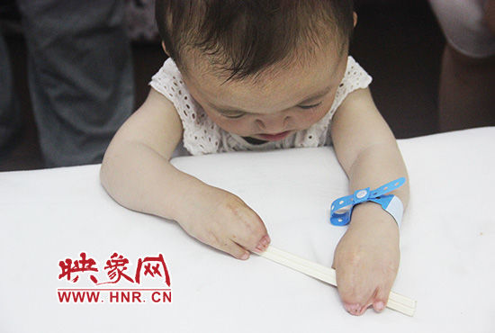 孩子握著筷子發(fā)呆。