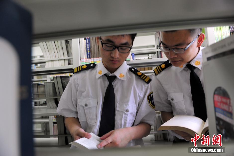 5月8日，武漢輕工大學(xué)圖書館保安吳濤與江力在圖書館交流學(xué)習(xí)。