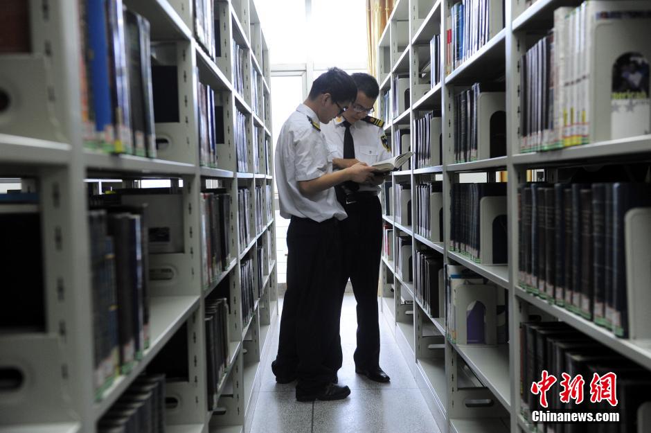 5月8日，武漢輕工大學(xué)保安吳濤與江力在圖書館交流學(xué)習(xí)。中新社發(fā) 張暢 攝