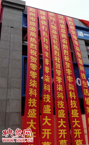 路邊一棟樓上懸掛著二三十條紅色條幅，全部是祝賀一家公司開業(yè)的。