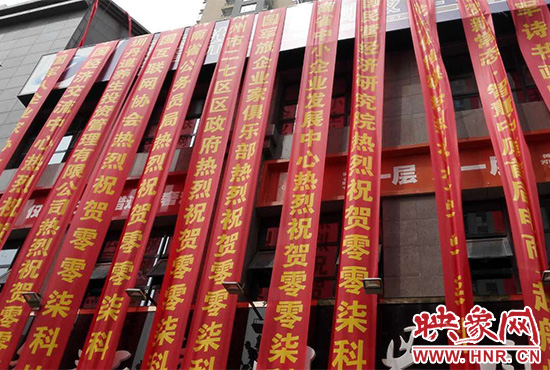 路邊一棟樓上懸掛著二三十條紅色條幅，全部是祝賀一家公司開業(yè)的。