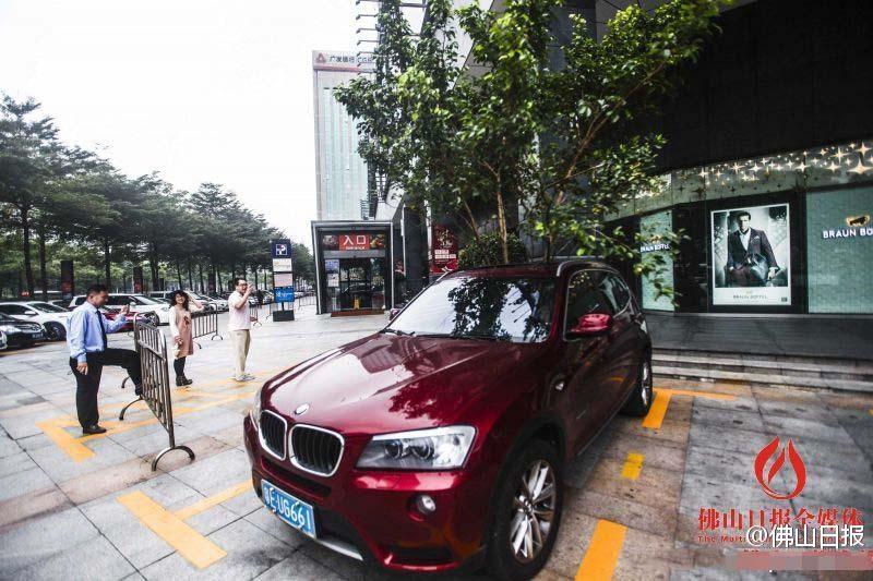 一輛停在停車位上的寶馬轎車，被墜落的樹枝砸中，樹枝徑直插入車內(nèi)，現(xiàn)場引發(fā)不少市民圍觀拍照。