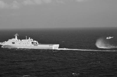 11日，抵達(dá)馬航飛機(jī)失聯(lián)海區(qū)的海軍井岡山艦與艦載直升機(jī)協(xié)同展開(kāi)立體搜救行動(dòng)。新華社發(fā)