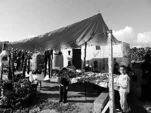 黎巴嫩一敘利亞難民營(yíng)，難民支起攤鋪賣衣服掙錢。
