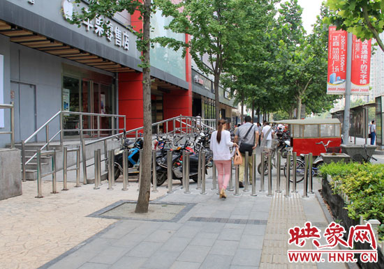 圖中道路左側(cè)的無(wú)障礙通道被鋼管隔離,右側(cè)的盲道也被侵占。