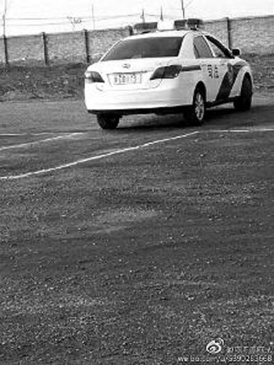 一輛車牌號 為“ 陜DD173”的制式警車停在一個劃著白線的場地上，車身標有“司法”字樣