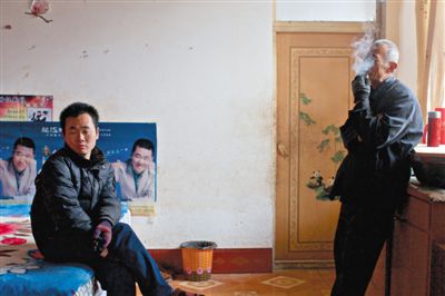 父親抽煙，兒子不語(yǔ)。逃跑的越南新娘，給袁迎賓父子帶來(lái)的是失落。新京報(bào)記者 周崗峰 攝