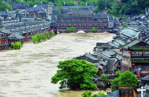 7月16日,沱江兩邊的商鋪和遠(yuǎn)處的虹橋仍淹沒在洪水中。 新華社發(fā)