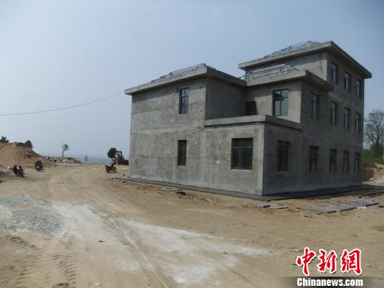 鴨河水庫(kù)庫(kù)區(qū)邊的新建別墅，一面墻上寫著“拆”，另一邊在加緊施工。吳揚(yáng)　攝